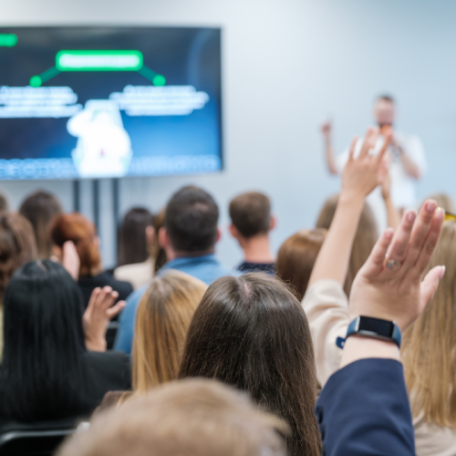 People raising hand engaged in discussion.